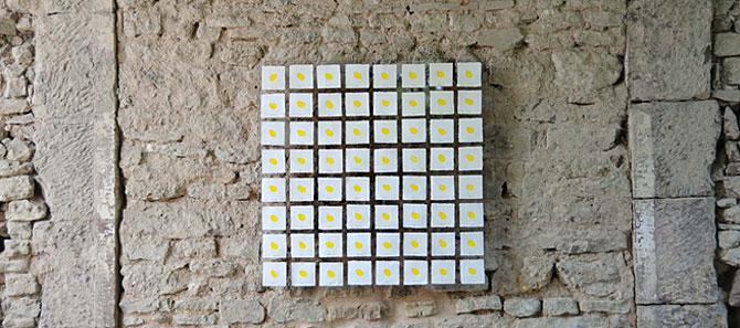 64 quadratische, mit einem gelben Punkt bestempelte Papierkärtchen